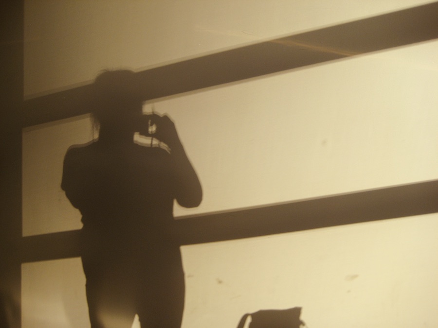 Shadow image on a wall of Rhonda Jesckey standing, holding a camera. Photography by Rhonda Jesckey 