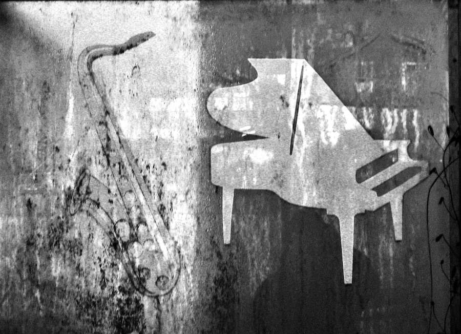 A saxophone and a piano etched on a glass panel. Photography by Rhonda Jesckey