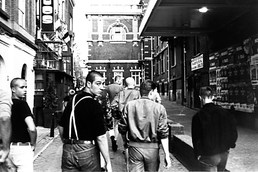 Backview of skinheads walking down a street in Amsterdam. Two turn around when they heard the shutter. Photography by Rhonda Jesckey.