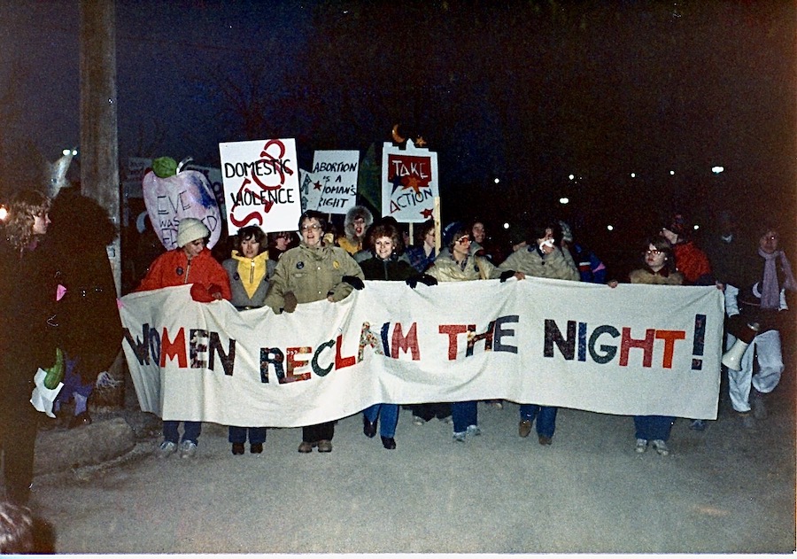 A protest march with women holding a Women Reclaim The Night banner in Calgary, Alberta. Photography by Rhonda Jesckey